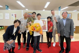 贈呈式の後、沖縄の関係者と記念写真に収まる柳生千裕さん＝沖縄県那覇市（真栄城徳七さん提供）