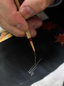 ネズミの毛で作った筆で細い線を描く。意外と楽しい＝神戸市中央区の蒔絵教室（撮影・三津山朋彦）