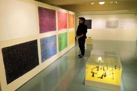 ポルトガル語の言葉を波のように描いた絵や陶芸作品が並ぶ＝神戸市中央区山本通３、神戸市立海外移住と文化の交流センター