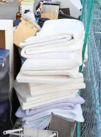 風俗営業に使われていた布団やマットレスなど、店の備品が粗大ゴミとして山積み＝１６日午後、尼崎市神田南通３