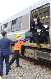 ドアからの避難を体験する参加者＝３０日午後０時４３分、兵庫県太子町、網干総合車両所