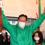 当選確実となり、タイを掲げる関芳弘氏＝神戸市須磨区大池町２（撮影・吉田敦史）