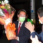 接戦を制し、花束を掲げて喜ぶ日本維新の会の市村浩一郎氏＝宝塚市逆瀬川２（撮影・中西幸大）