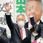 たつの市長選で当選確実の報道を受け、万歳する現職・山本実氏＝たつの市龍野町富永の事務所