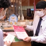 ワクチン接種済証を確認する飲食店員（右）＝１日午後、神戸市長田区南駒栄町