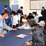 沼島小であった避難所の設営訓練で、簡易ベッドを組み立てる住民ら＝南あわじ市沼島