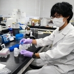 下水中のウイルス関連物質を見つける作業手順を示す谷本佳彦研究員＝神戸市中央区港島中町４