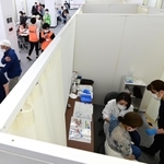 ずらりと並ぶブース内でワクチン接種を受ける高齢者ら＝５月、神戸市内