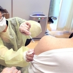 二の腕を出して行われるワクチンの接種。厚着になりがちな冬場は着脱に時間がかかりそう＝５月、神戸市内