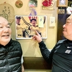 ２５年前の優勝パレードの中嶋監督の写真を見ながら談笑する木下大輔さん（右）と父の一夫さん＝神戸市須磨区大田町２