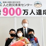 入館９００万人目の記念品を受け取った野口千太君（前列左）ら＝人と防災未来センター