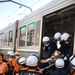 列車のドアから線路への避難を体験する参加者＝兵庫県太子町
