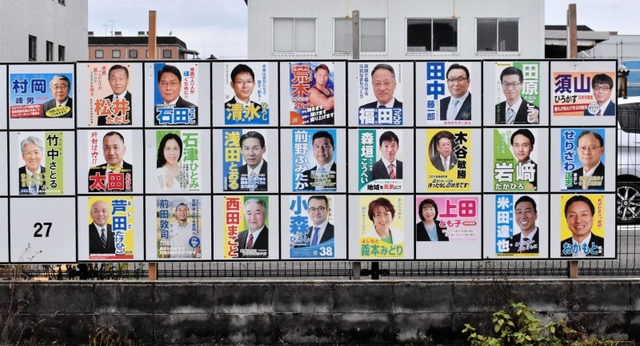 候補者の顔がずらりと並ぶポスター掲示板。上段中央が荒木さんのポスター＝豊岡市内