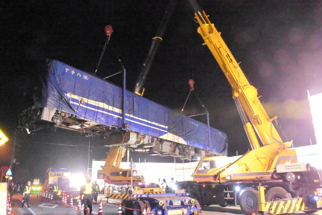 クレーン２台でつり上げ、線路に移されるキハ４０形＝１２日午前０時半、加西市西横田町