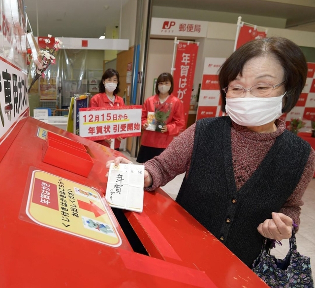 特設ポストに年賀状を投かんする女性＝１５日午前、神戸市中央区栄町通６（撮影・秋山亮太）