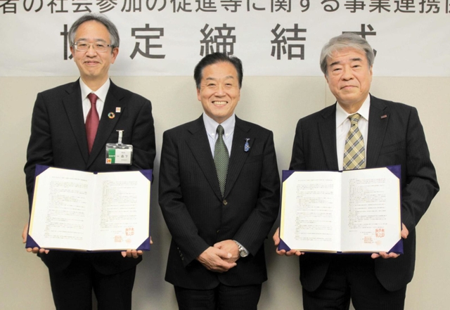 協定書を手にする（右から）ラジオ関西の桃田武司社長、パーソナリティーの三上公也さん、神戸市の森下貴浩福祉局長＝同市役所
