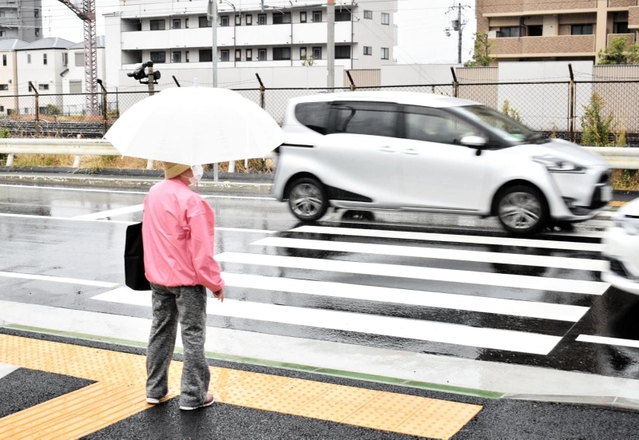 横断歩道を渡ろうとする歩行者の前を車両が行き交う＝７日、神戸市灘区灘北通８