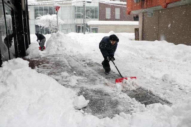 開店に向けて雪かきをする但馬信用金庫の職員＝２７日午前７時５６分、朝来市和田山町東谷（撮影・竜門和諒）