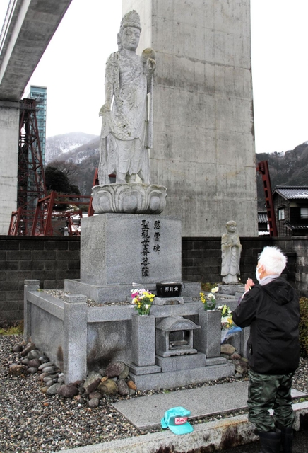 慰霊碑の観音像の前で手を合わせる北村忠久さん＝２８日午後、兵庫県香美町香住区余部