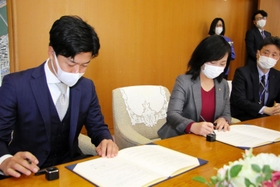 協定書に署名するクラッソーネの川口哲平代表取締役ＣＥＯ（手前）と尼崎市の稲村和美市長＝尼崎市役所