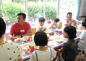 交流会で給食を食べながら触れ合うインドネシア人技能実習生と児童たち＝２０１９年７月、兵庫県新温泉町諸寄、浜坂西小学校（同小提供）