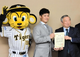 寄付への感謝状を受け取る坂本誠志郎選手（中央）。阪神のマスコット「トラッキー」も場を盛り上げた＝兵庫県庁