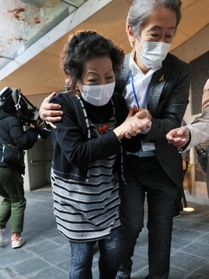 阪神・淡路大震災後の１９９７年に亡くなった森口政則さんの名前が刻まれた銘板を貼り終えて、おえつする妻マス美さん＝１１日午後、神戸市中央区加納町６（撮影・鈴木雅之）