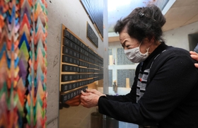 阪神・淡路大震災後の１９９７年に亡くなった森口政則さんの名前が刻まれた銘板を貼り付ける妻マス美さん＝１１日午後、神戸市中央区加納町６（撮影・鈴木雅之）