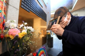 阪神・淡路大震災で母と姉を亡くした増田潤さん。銘板を取り付けると、おえつが止まらなかった＝１１日午後、神戸市中央区加納町６（撮影・鈴木雅之）