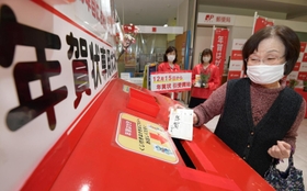 特設ポストに年賀状を投かんする女性＝１５日午前、神戸市中央区栄町通６（撮影・秋山亮太）