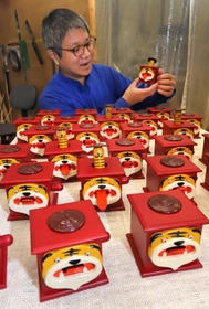 トラの親子の動きが心和ませる干支の神戸人形と、製作者の吉田太郎さん＝神戸市東灘区住吉山手８