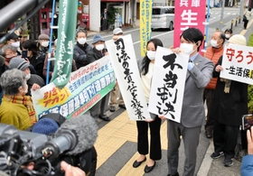 原告の訴えが退けられ、「不当判決」の垂れ幕を掲げる弁護団＝１６日午後、神戸市中央区橘通２、神戸地裁