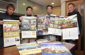 新旧の秋祭りカレンダーを手にする大和良作さん（左）ら製作メンバー＝姫路市木場