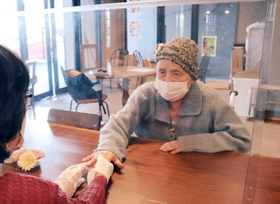 同じ部屋でパーティション越しに面会する入所者と家族。感染が落ち着き、措置が緩和された＝神戸市垂水区名谷町、花の森