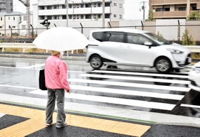 横断歩道を渡ろうとする歩行者の前を車両が行き交う＝７日、神戸市灘区灘北通８