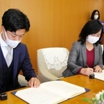 協定書に署名するクラッソーネの川口哲平代表取締役ＣＥＯ（手前）と尼崎市の稲村和美市長＝尼崎市役所