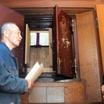 関西学院大の「旧院長室」を訪ね、現存する奉安庫について職員に質問する貴島正秋さん（左）＝西宮市上ケ原一番町
