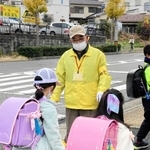 「おはよう、気を付けてな」と声を掛ける藤田和彦さん。１５年以上、登校時の子どもたちを見守ってきた＝神戸市垂水区