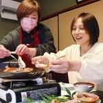 「かにソムリエ」として松葉ガニの食べ方を宿泊客に伝える清水左知子さん（左）＝１日、兵庫県新温泉町七釜、清水や