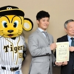 寄付への感謝状を受け取る坂本誠志郎選手（中央）。阪神のマスコット「トラッキー」も場を盛り上げた＝兵庫県庁