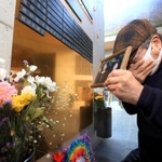 阪神・淡路大震災で母と姉を亡くした増田潤さん。銘板を取り付けると、おえつが止まらなかった＝１１日午後、神戸市中央区加納町６（撮影・鈴木雅之）
