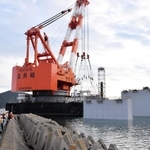 設置された浮上式水門。外枠部分が海面から出ている＝１６日午後、南あわじ市の福良湾