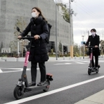 電動キックボードの実証実験で、ヘルメットをかぶらずに公道を走る神戸市職員＝神戸市中央区新港町