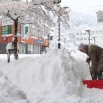 降り続く雪の中、雪かきをする女性＝２７日午前８時５分、朝来市和田山町東谷（撮影・竜門和諒）