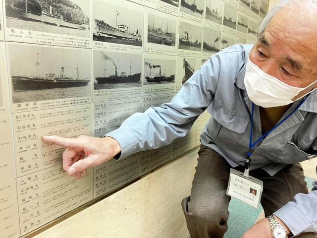 第３弥栄丸の銘板を指さす岡村世紀一さん。撃沈された民間船７千隻のうち、写真が残るのは３割にも満たないという＝神戸市中央区、「戦没した船と海員の資料館」