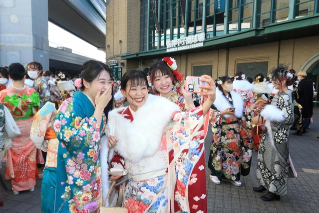 記念撮影の時だけマスクを外し、友人と笑顔を見せる新成人たち＝１０日午後、西宮市甲子園町、甲子園球場（斎藤雅志）