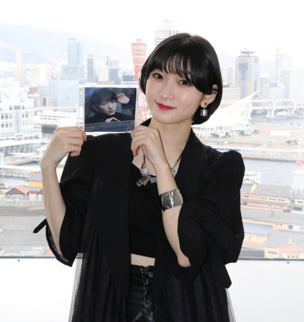 ファーストシングルを手にする歌手の宮本佳林＝神戸市中央区東川崎町１、神戸新聞社