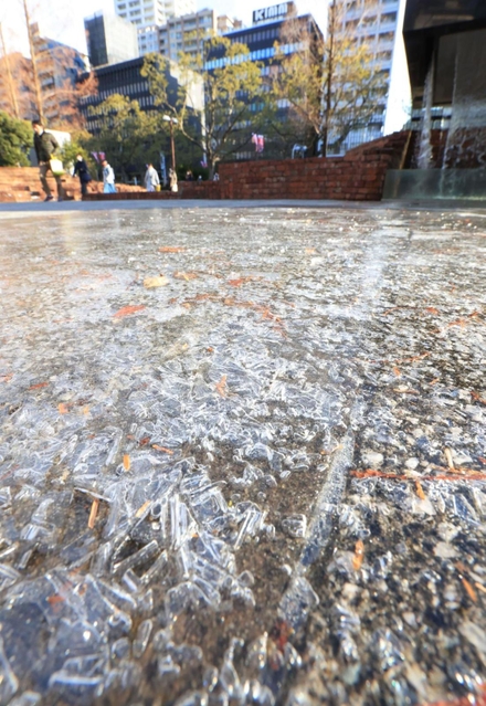 厳しい冷え込みで凍結した水たまり＝１４日午前、神戸市中央区加納町６