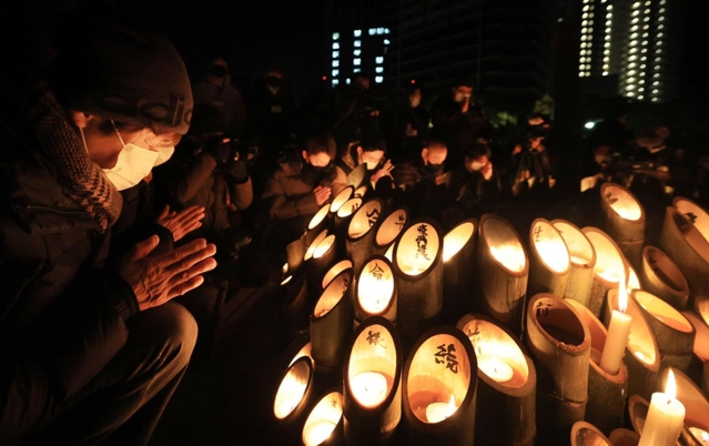 発生時刻に合わせて手を合わせる人たち＝１７日午前５時４６分、神戸市中央区加納町６、東遊園地（撮影・鈴木雅之）