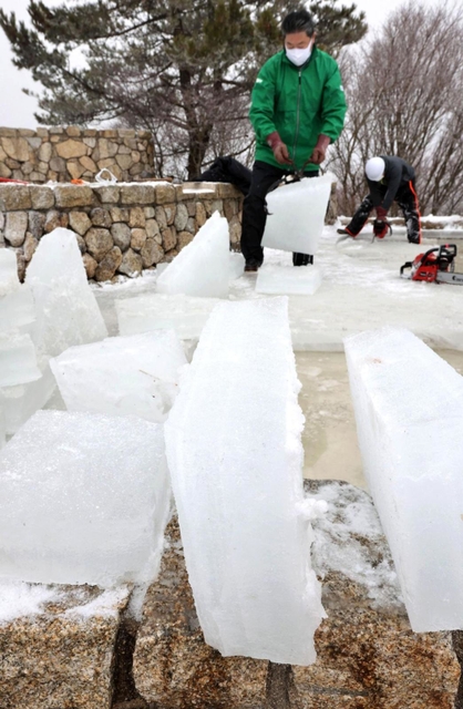 氷棚に分厚くできた氷を切り出す職員ら＝２０日午前、神戸市灘区六甲山町